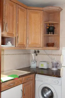 a kitchen with a washing machine and wooden cabinets at Beach Center 2 - 300m beach in Albufeira
