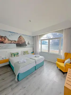 a bedroom with a bed with two towels on it at Golden Beach Guest House & Rooftop Bar in Faro