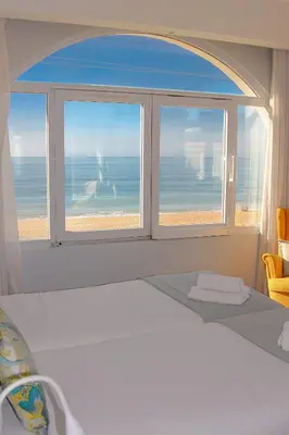a hallway with a staircase with a mirror on the wall at Golden Beach Guest House & Rooftop Bar in Faro