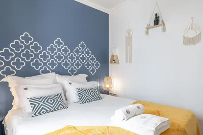 a bedroom with a bed with a blue wall at Main Street Apartments by Raspberry Cascade in Faro