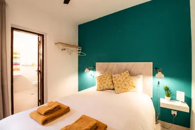 a bedroom with a large bed with a green wall at Quinta do Paraíso - Bed&Shower in Albufeira