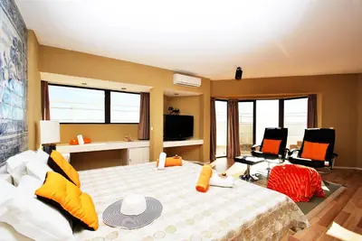 a bedroom with a large bed with yellow and orange pillows at Penthouse Miami by Algarve Vacation in Albufeira