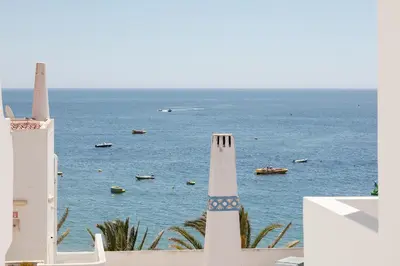 a view of the ocean with boats in the water at Pé na Praia in Albufeira