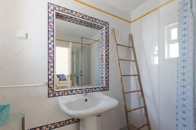a bathroom with a sink and a mirror at Pé na Praia in Albufeira