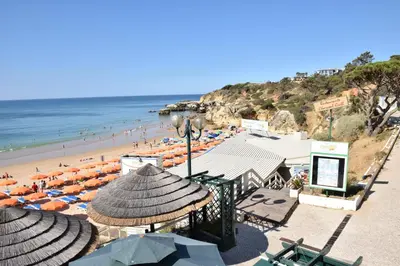 a beach with umbrellas and people on the beach at Pé na Praia in Albufeira