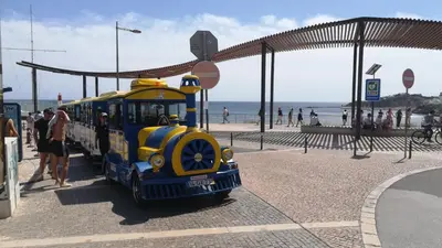 a small train engine on a beach with people at Beach Falésia Alfamar in Albufeira