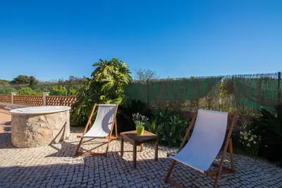 a pool with chaise lounge chairs and a swimming pool at Quinta das Yuccas in Boliqueime