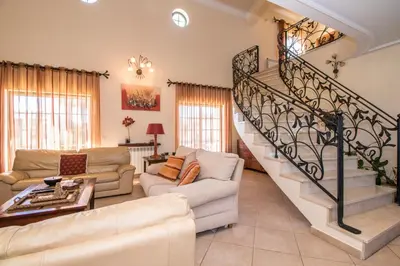 a living room with a staircase with couches at Quinta das Yuccas in Boliqueime