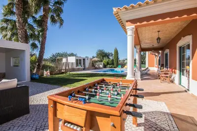 a villa with a swimming pool in front of a house at Quinta das Yuccas in Boliqueime