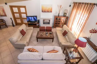 a living room with white couches and a tv at Quinta das Yuccas in Boliqueime