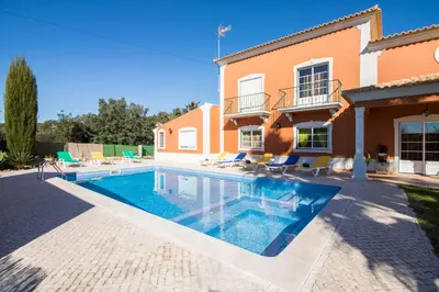 a backyard with a pool and a house at Quinta das Yuccas in Boliqueime