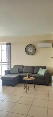 a living room with a couch and a clock on the wall at Casa Sensa in Albufeira