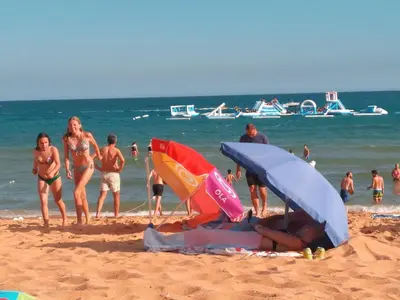 a group of people on a beach with umbrellas at Casa Sensa in Albufeira
