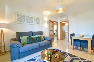 a living room with a blue couch and a table at L14 by MTPhomes in Vale de Pedras