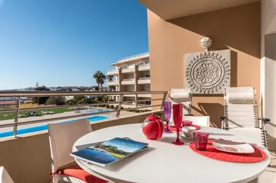 a table and chairs on a balcony with a view at Beachfront flat, private parking, pools, sea at less than 200 m in Albufeira
