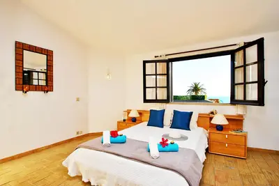 a bedroom with a large bed with blue pillows at Villa Mauritius by Algarve Vacation in Albufeira