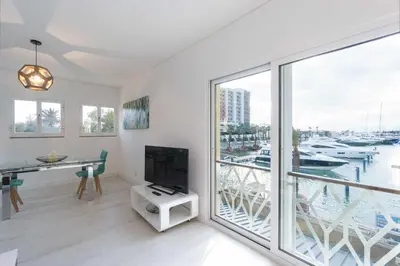 a living room with a tv and a large window at Boat View - Marina Plaza - By VilamouraSun in Vilamoura