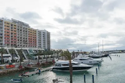 a group of boats docked in a marina with buildings at Boat View - Marina Plaza - By VilamouraSun in Vilamoura