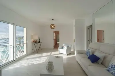 a white living room with a couch and a table at Boat View - Marina Plaza - By VilamouraSun in Vilamoura