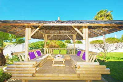 a wooden gazebo with chairs and a table at Villa Buddha by Algarve Vacation in Albufeira