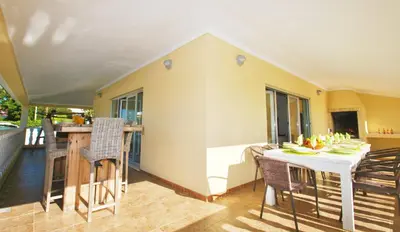 a room with a table and chairs and a kitchen at Villa Buddha by Algarve Vacation in Albufeira