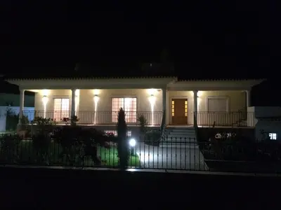 a person standing in front of a house at night at Fonte Santa Villa in Quarteira