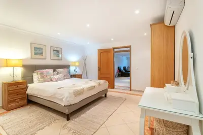 a bedroom with a bed and a sink and a mirror at Fonte Santa Villa in Quarteira