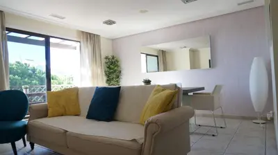a living room with a couch and a mirror at Apartment Calcada in Albufeira