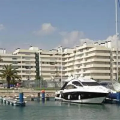 a boat is docked in the water near a building at Marina Vilamoura Apartment in Vilamoura