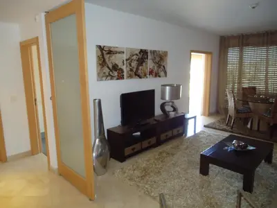 a living room with a tv and a table at Marina Vilamoura Apartment in Vilamoura