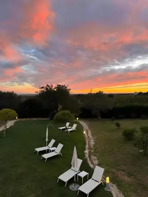 a group of chairs and tables on a field at sunset at Mercedes Country House in Faro