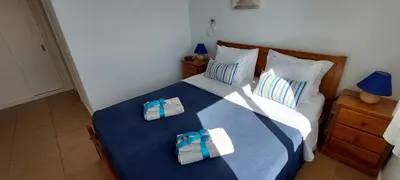 a bedroom with a bed with two towels on it at Varandas de Carteia in Quarteira