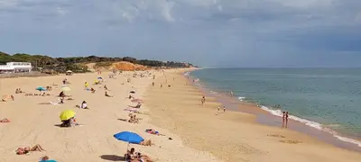 a group of people on a beach with the ocean at Varandas de Carteia in Quarteira
