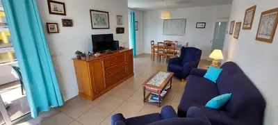 a living room with two blue chairs and a tv at Varandas de Carteia in Quarteira