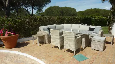 a patio with a table and chairs on a brick patio at Casa Vila Verde in Quarteira