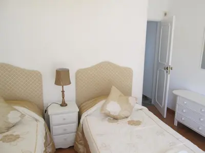 a bedroom with two twin beds and a night stand at Casa Vila Verde in Quarteira