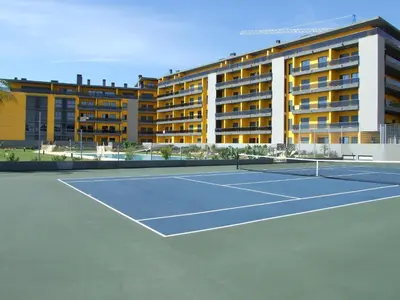 a tennis court in front of a hotel at Parque Atlântico in Quarteira