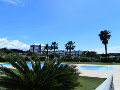 a view of a swimming pool with palm trees at Parque Atlântico in Quarteira