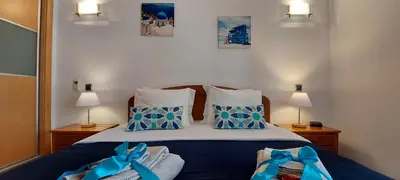 a bedroom with a bed with blue and white pillows at Parque Atlântico in Quarteira