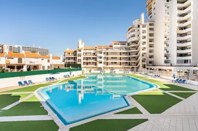 a large swimming pool in front of some apartment buildings at Aqua Magna Apartment in Albufeira