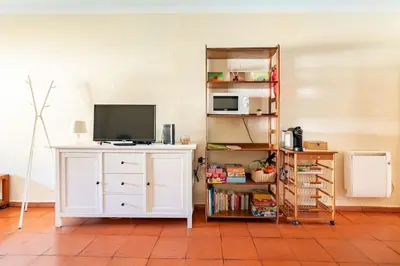a living room with a tv on a white cabinet at Aqua Magna Apartment in Albufeira