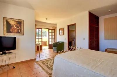 a bedroom with a bed and a flat screen tv at Charming House Vilamoura in Vilamoura