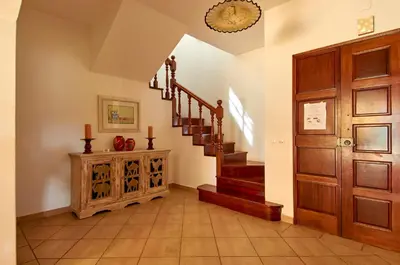 a hallway with a staircase and a wooden door at Charming House Vilamoura in Vilamoura