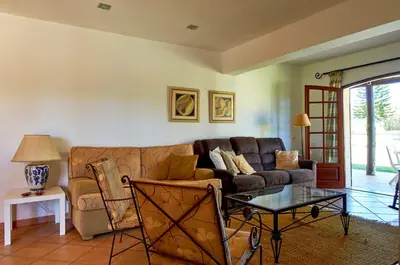 a living room with a couch and a glass table at Charming House Vilamoura in Vilamoura
