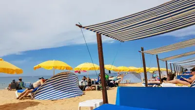 a group of chairs and umbrellas on a beach at Oura Lancemar by Sunny Deluxe in Albufeira