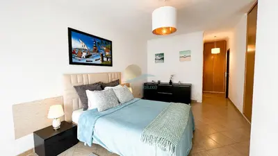 a bedroom with a bed and a tv on the wall at Oura Lancemar by Sunny Deluxe in Albufeira