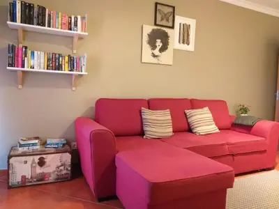a living room with a red couch and a ottoman at MSHomes Corcovada in Albufeira