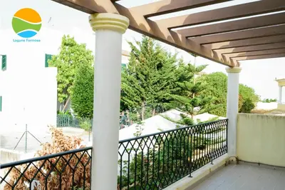 a balcony of a house with a fence and a pillar at Laguna Formosa in Faro