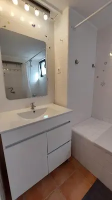 a white bathroom with a sink and a mirror at Sailing Studio Açoteias in Albufeira