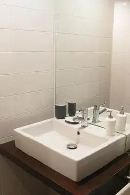 a bathroom with a white sink and a mirror at Acoteias Beach Studio in Albufeira